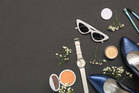 Composition with female accessories, cosmetics, heels and gypsophila flowers on dark backgroundの写真素材