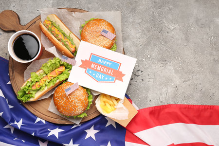 Wooden board with tasty dishes, drink, greeting card and American flag on grunge background. memorial day celebrationの写真素材