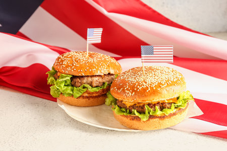 Plate with tasty burgers and American flag on light background. memorial day celebrationの写真素材