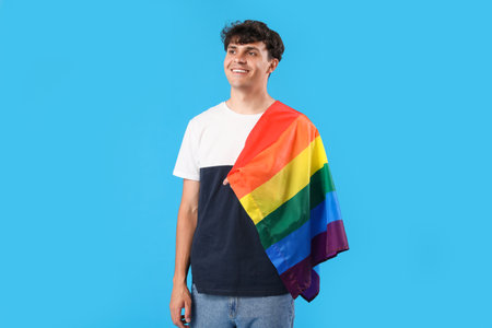 Young man with LGBT flag on blue backgroundの写真素材