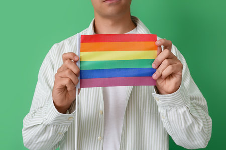 Young man with LGBT flag on green background, closeupの写真素材