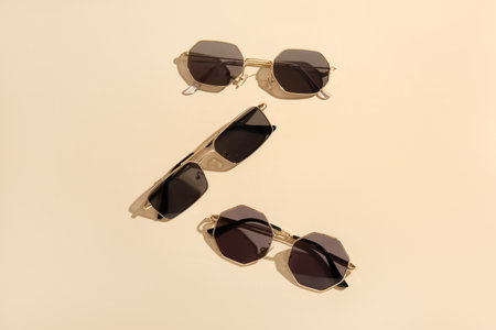 Different stylish sunglasses on beige backgroundの写真素材