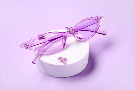 Podium with stylish sunglasses on lilac backgroundの写真素材