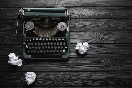 Vintage typewriter with crumpled paper on black wooden backgroundの写真素材