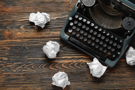 Vintage typewriter with crumpled paper on brown wooden backgroundの写真素材