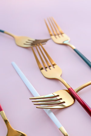 golden forks on pink backgroundの写真素材