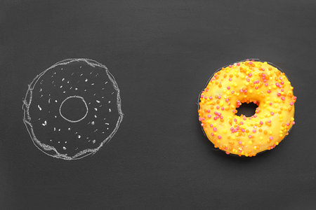 Fresh and drawn donuts on black backgroundの写真素材