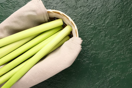 Wicker bowl with fresh leeks on green backgroundの写真素材