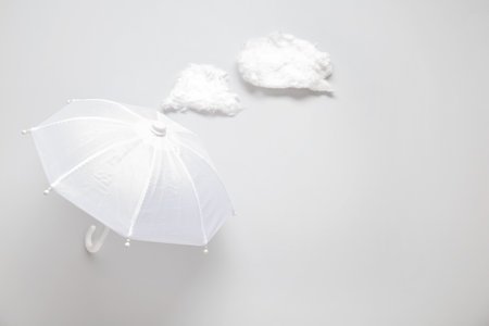 Composition with umbrella and clouds on white backgroundの写真素材