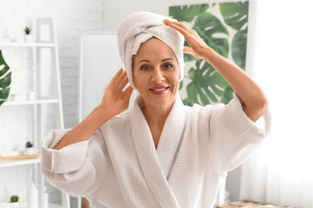 Mature woman with towel in bathroomの写真素材