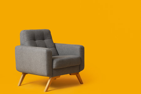 Cozy gray armchair on orange backgroundの写真素材