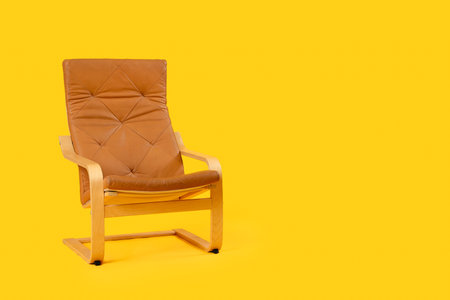 Cozy brown armchair on orange backgroundの写真素材