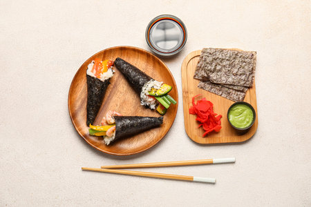 Composition with tasty sushi cones, ingredients and chopsticks on light backgroundの写真素材