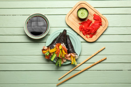 Plate with tasty sushi cones, soy sauce, ginger and wasabi on color wooden background
