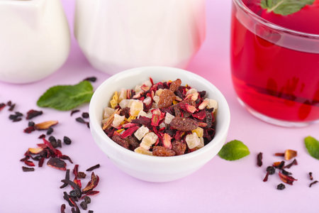 Bowl with dried fruit tea on pink background, closeup