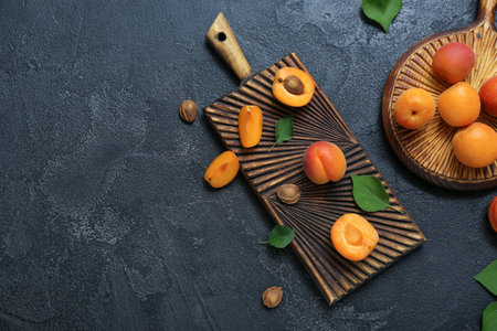 Boards with fresh apricots and leaves on black backgroundの写真素材