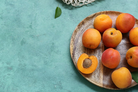 Plate with fresh apricots on green backgroundの写真素材
