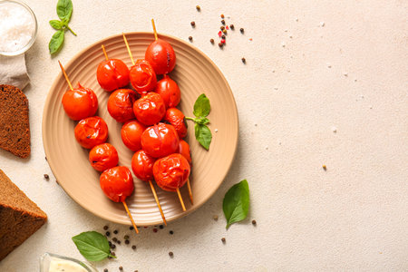 Plate of skewers with tasty grilled tomatoes and basil on white backgroundの写真素材