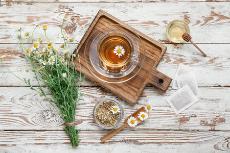 Cup of hot chamomile tea on light wooden backgroundの写真素材