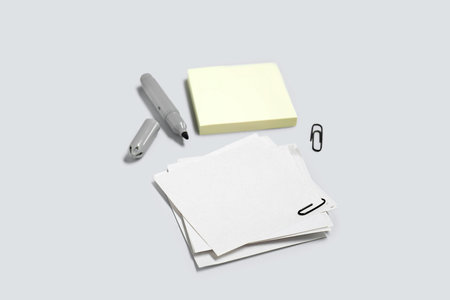 Sticky notes with paper clips and marker on gray background