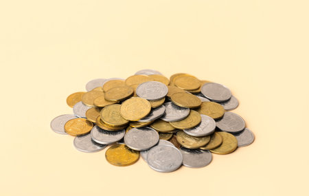 Heap of coins on beige backgroundの写真素材