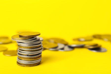 Stack of coins on yellow backgroundの写真素材
