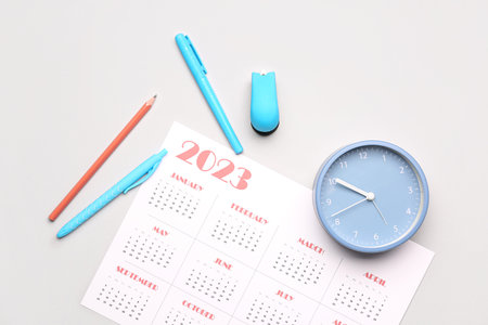 Calendar, pencils and clock on gray background