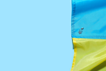 Pendant with Ukrainian coat of arms and flag on blue background, closeup