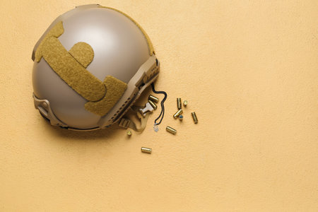 Military helmet, bullets and chain with Ukrainian coat of arms on beige backgroundの写真素材