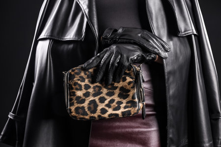 Stylish young woman in leather gloves with bag on dark background, closeupの写真素材