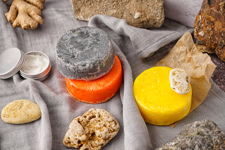 Different handmade solid shampoo, cream and stones on tableの写真素材