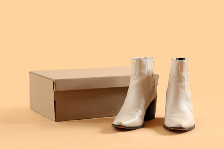 Cardboard box with heeled shoes on beige backgroundの写真素材