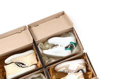 Cardboard boxes with different stylish sneakers on white background