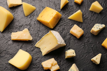 Pieces of tasty cheese on dark backgroundの写真素材