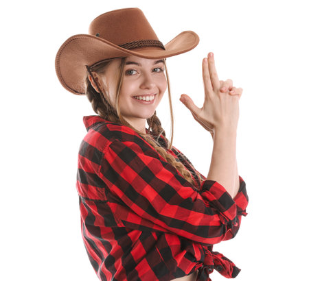 Young cowgirl showing gun gesture on white backgroundの写真素材