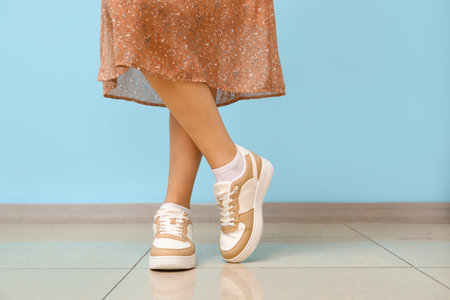 Woman in stylish sneakers against color wallの写真素材