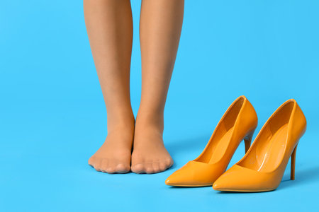 Female legs in tights with stylish high heels on color background, closeupの写真素材