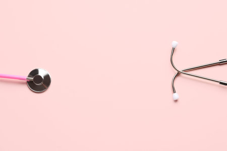 Modern stethoscope on pink background