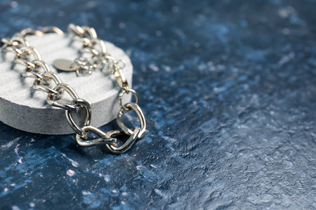 Decorative podium with silver necklace on grunge blue backgroundの写真素材