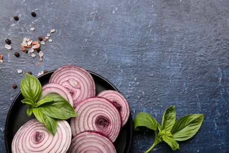 Plate with fresh onion and spices on blue backgroundの写真素材