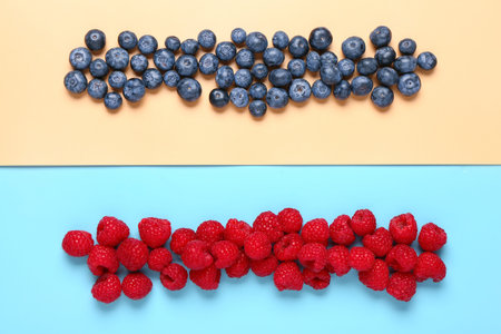 Fresh blueberries and raspberries on colorful background