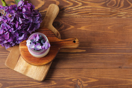 Glass of panna cotta with blueberry and beautiful hydrangea flowers on wooden backgroundの写真素材