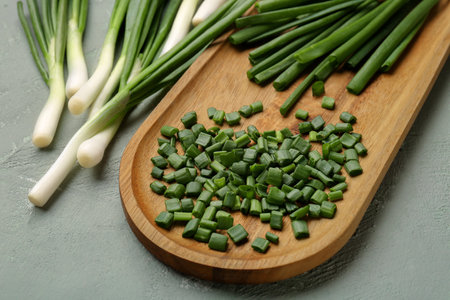 Board with slices of fresh green onion on gray backgroundの写真素材