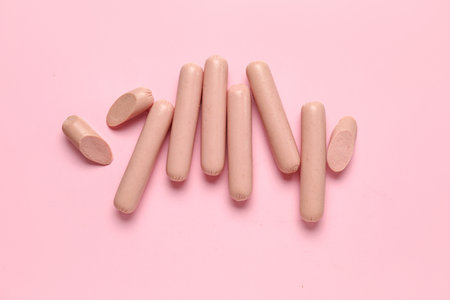 Tasty thin sausages on pink backgroundの写真素材