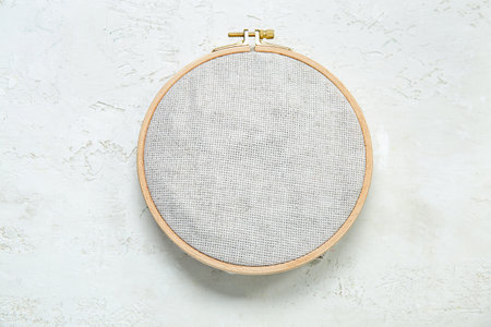 Wooden embroidery hoop with canvas on grunge white backgroundの写真素材