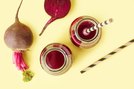 Bottles of healthy beet juice on yellow backgroundの写真素材