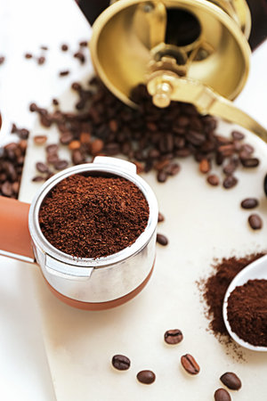 Portafilter with coffee powder on light background