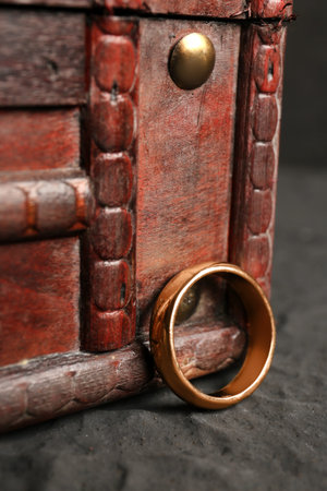 Decorative trunk box and beautiful ring on black background, closeup
