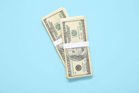 Bundles of one hundred dollar banknotes on blue background
