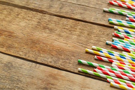 Different paper drinking straws on wooden backgroundの写真素材
